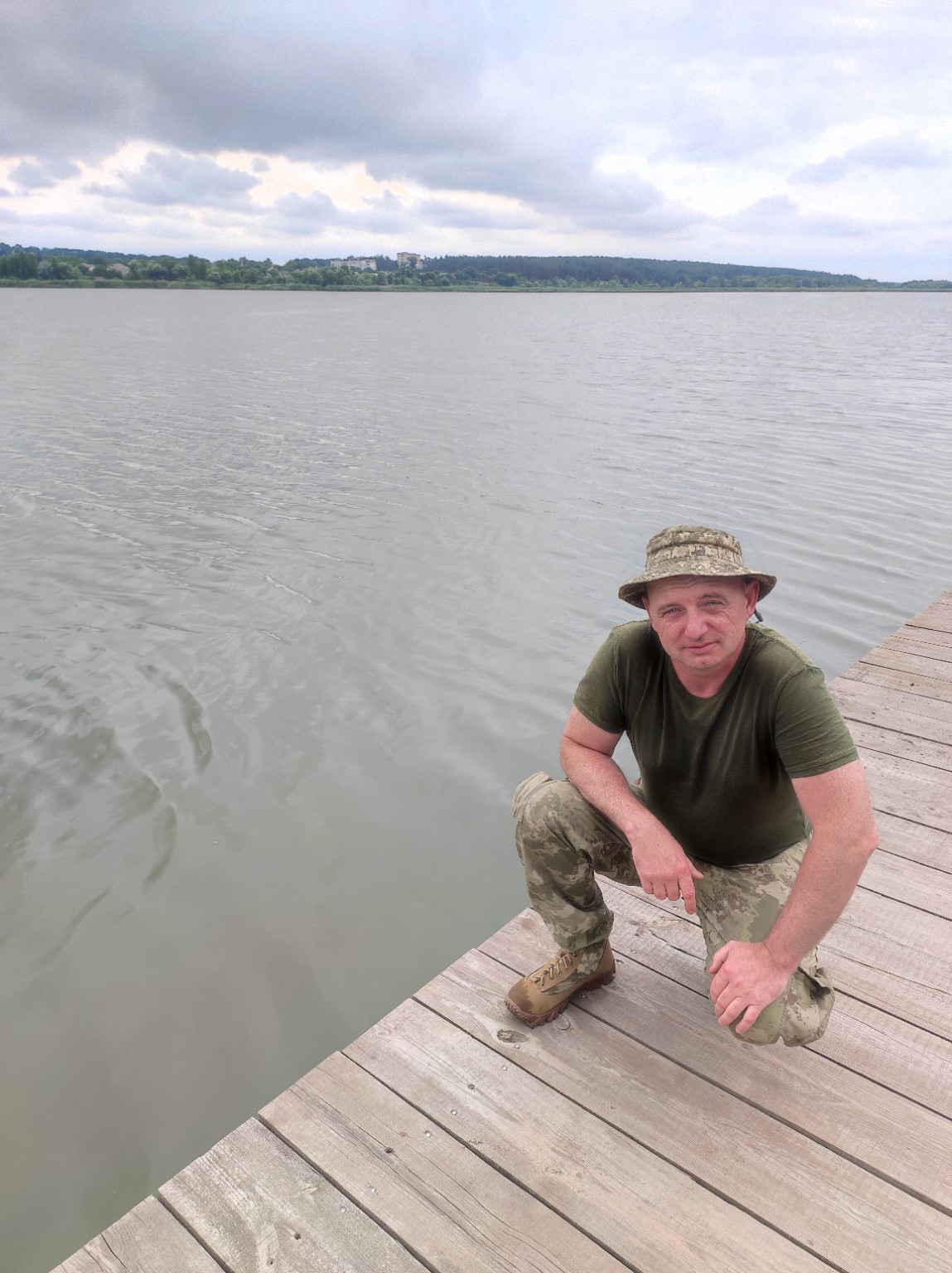 Petro sitting on a wooden pier beside a lake